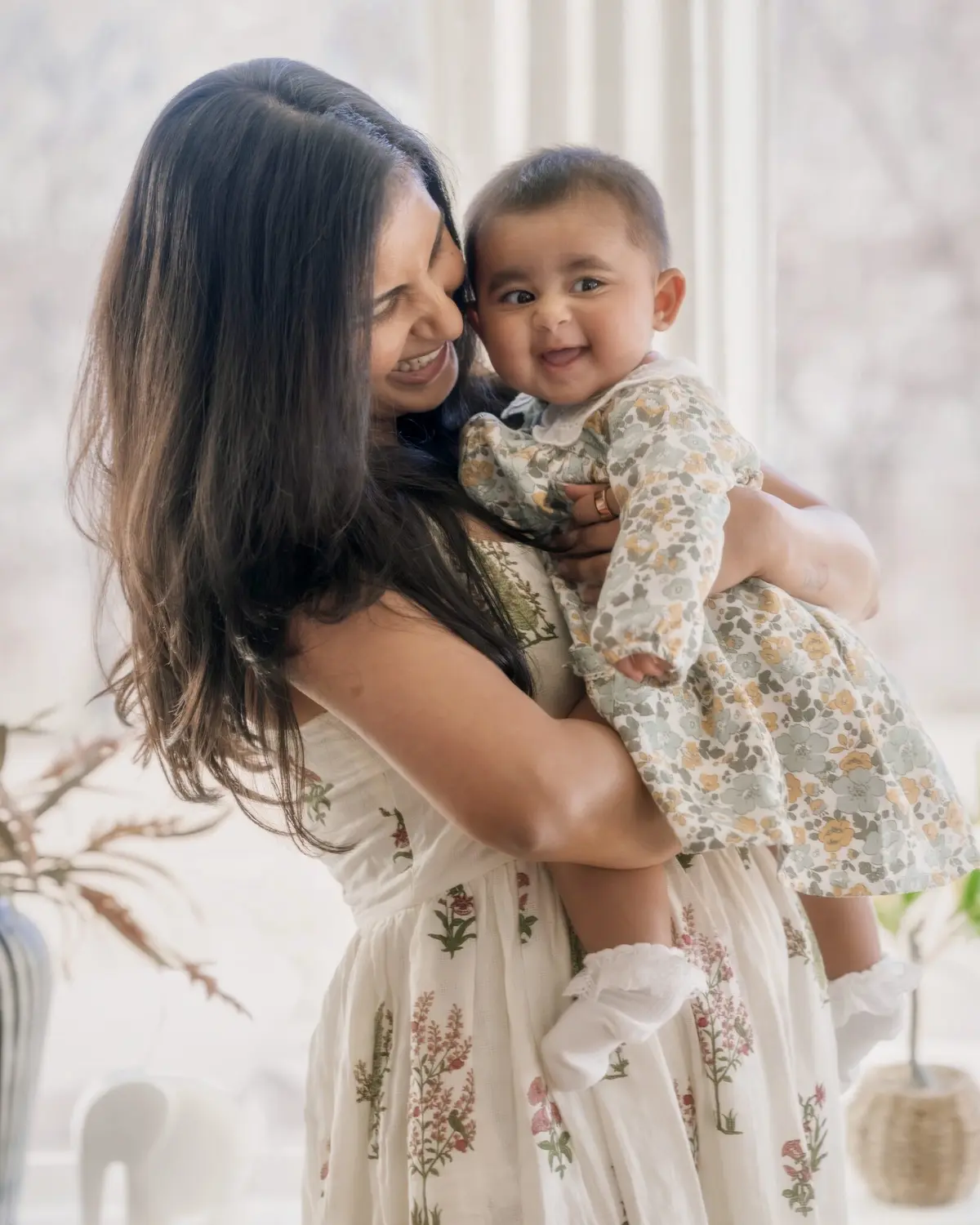 Arya laughing in her amma's arms