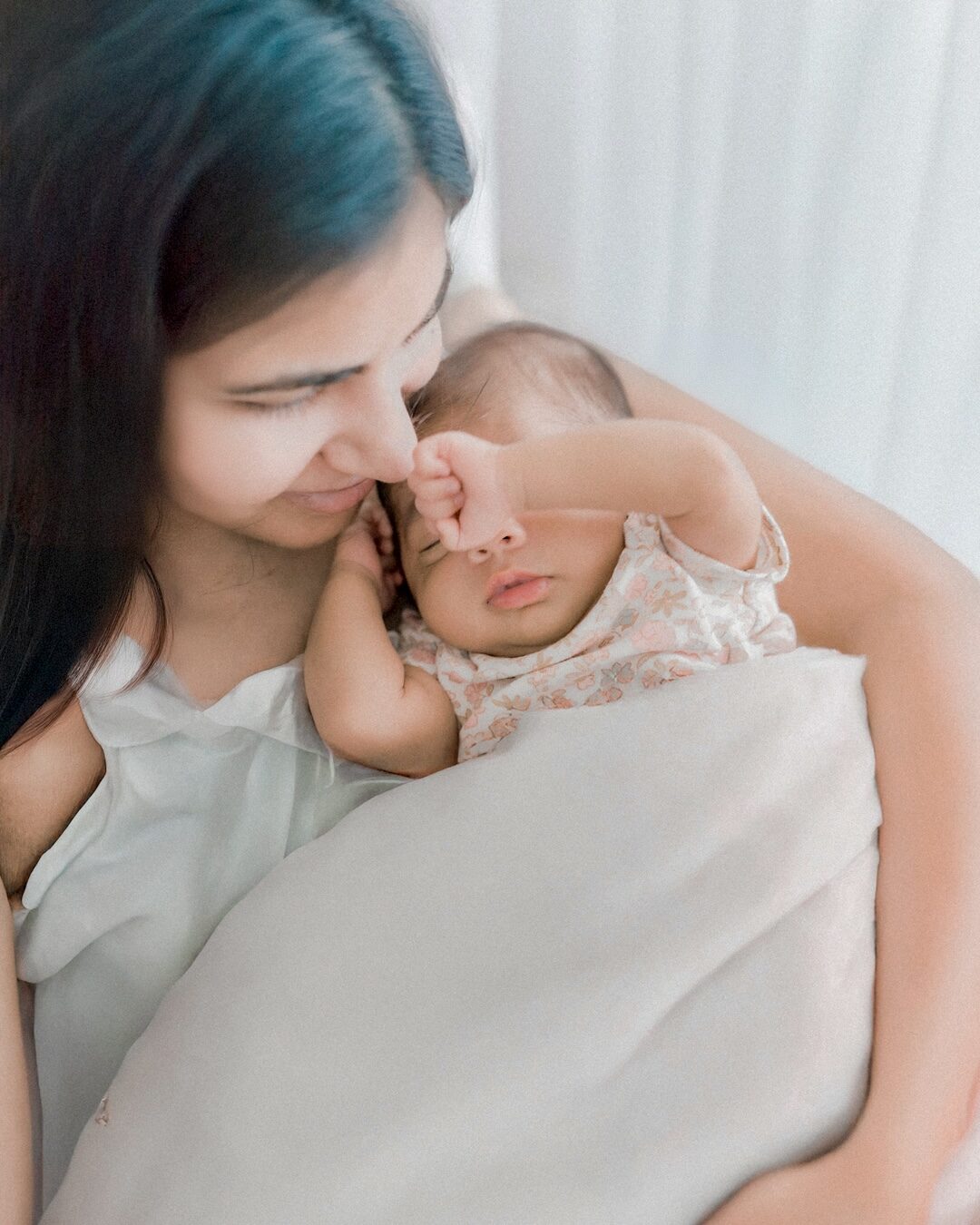 Arya cradled in her amma's arms as a newborn